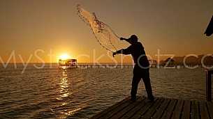 Cast Net from a dock at sunset